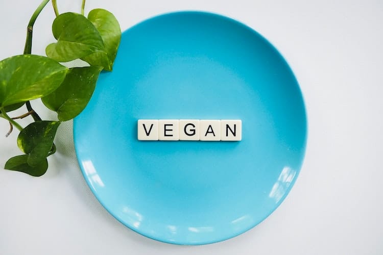 A blue plate with the word VEGAN written on it