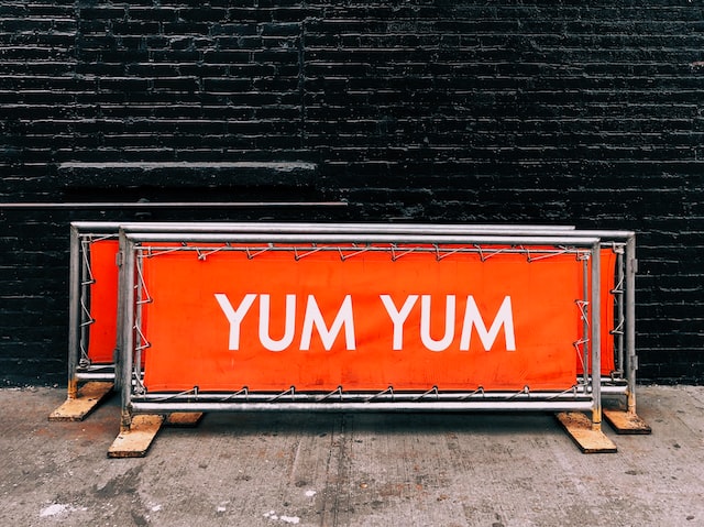 A sign saying 'yum yum' portraying sustainable NYC restaurants offering delicious food.