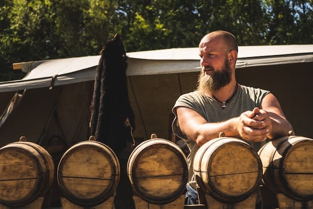 a man with wine barrels depicts