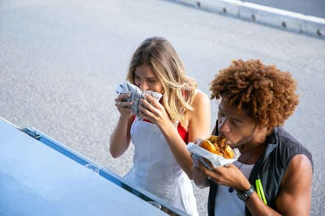 Two people eating street food and exploring New York's varied food truck scene.